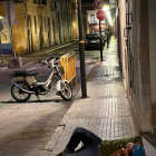 Un hombre con una lata estirado en una calle del barrio del Port.