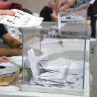 Una persona introdueix el seu vot en una urna del col·legi Fedac de Lleida.