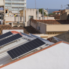 Imatge de plaques solars fotovoltaiques instal·lades a la teulada d'un immoble.