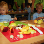 Fruta en primer término que han cortado los niños que han participado en el taller organizado por Unió de Pagesos en el casal de la Escuela Montsant de Reus.
