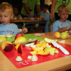 Fruita en primer terme que han tallat els infants que han participat en el taller organitzat per Unió de Pagesos al casal de l'Escola Montsant de Reus.