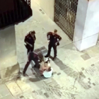 Captura del vídeo del moment en què l'agent dels mossos venta una bufetada a l'home assegut al mig del carrer a Olot.