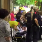 Técnicos del SEM atendiendo al paciente que han tenido que reducir los Mossos en la calle Rovira i Virgili.