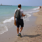 Iván Cáceres, investigador del Laboratorio de Ingeniería Marítima de la Universidad Politécnica de Cataluña, de espaldas, haciendo una barometría en la playa de Altafulla.