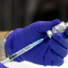Una jeringuilla succionando una dosis de la vacuna contra la cóvid-19.