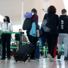 Pasajeros en el aeropuerto de El Prat en dirección a la zona de embarque.