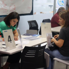 Una mujer entregando su currículum a una de las empresas participantes en el Job Dating en Tarragona.