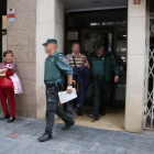Dos agents de la Guàrdia Civil sortint amb un detingut en un dels registres fets a Tarragona l'operatiu policial conjunt amb els Mossos d'Esquadra.