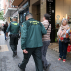 Dos policies de la Guàrdia Civil sortint amb un detingut en un dels registres fets a Tarragonal'operatiu policial conjunt amb els Mossos d'Esquadra.