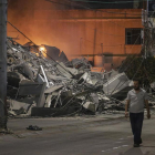 Un palestino pasa junto a las secuelas de un ataque aéreo israelí en la ciudad de Gaza.