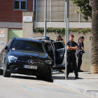 Agentes de los Mossos vigilando la puerta del edificio donde se encuentra atrincherado un hombre, en el barrio de Sarrià de Barcelona.