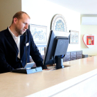 Un treballador atén una trucada a la recepció d'un hotel de Sitges.