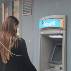 Una clienta del Banc Sabadell retirant efectiu d'un caixer.