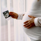 Una dona embarassada sostè una ecografia.
