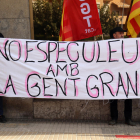 Dues persones subjectant una pancarta durant la concentració que ha tingut lloc aquest divendres davant els serveis territorials de Drets Socials a Tarragona.