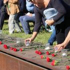 Familiars de víctimes de trànsit oferint flors i espelmes al memorial situat al passeig marítim de la Nova Icària de Barcelona.