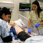 Dues infermeres pediàtriques fan pràciques a les aules de simulació de la URV.