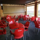 Imagen de archivo de la terraza de un bar con sillas y mesas Mahou.