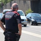 Un agent dels Mossos d'Esquadra supervisa els vehicles que surten de Barcelona per l'avinguda Meridiana.