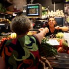 Una treballadora d'un dels comerços del Mercat Central de Tarragona atenent una clienta