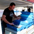 Un pescador preparant el peix a la barca per entrar-lo a la llotja de l'Ametlla de Mar.