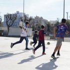 Diversos nens jugant en un pati d'una escola oberta els dissabtes.