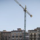 Una grua treballa en la construcció d'un edifici d'habitatges.