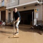 Un veí de l'Alcúdia, netejant el carrer després del pas de la dana.