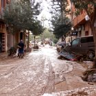 Un dels carrers de Picanya ple de fang i de veïns netejant