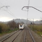 Imatge d'un tren circulant un dia de pluja