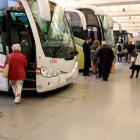 Desenes de passatgers pujants als autobusos a l'estacio de Tortosa.