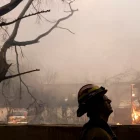 Un bomber del comtat de Los Ángeles observa un incendi a Altadena, Califòrnia.