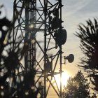 Una part de les antenes d'una torre de telecomunicacions amb el sol a punt de pondre's