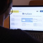 Una persona mirant la pàgina web de Muface