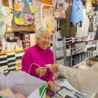 Fotografia d’una clienta pagant amb efectiu a la botiga de roba Lourdes, adherida a la campanya ‘Compra local, paga en efectiu