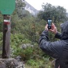 Un home fotografia una de les marques GR al sender que porta fins a l'ermita de Sant Blai a Tivissa