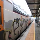 L'andana de les vies 0 i 1 de l'estació de Bellvitge-Gornal amb un tren aturat a l'espera que arribi un altre.