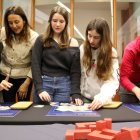 La consellera d'Educació, Esther Niubó, resolent problemes matemàtics amb alumnes al Museu de les Matemàtiques de Tarragona.