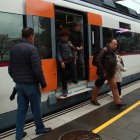 Usuaris baixant i agafant un tren de l'R2 Sud arribant a l'estació de Calafell
