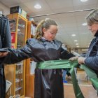 Una jove emprovant-se la vesta i la faixa per participar en la Setmana Santa