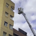 Bombers treballant a la façana afectada al carrer Jaume I de Reus.