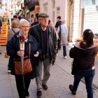 Una parella, ella amb una rosa a la mà, passeja entre parades de Sant Jordi a Tortosa.