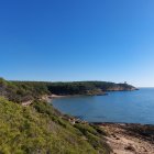 El sector litoral del Bosc de la Marquesa, amb la cala de la Roca Plana i, al fons, la torre de la Mora.