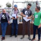 Membres d'Stop Creuers Tarragona revisen l'informe davant d'un parc infantil del port de Tarragona on es van prendre mostres.