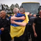 Presoners ucraïnesos intercanviats arran de l'acord entre Rússia i Ucraïna s'abracen al ser alliberats, portant a sobre una bandera ucraïnesa