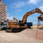 Una de les màquines omplint un dels camions per traspassar sorra del port de Coma-ruga cap a la platja de Calafell.