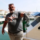 Un pescador de Cambrils sosté el dispositiu auditiu per allunyar els dofins.