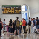 Usuaris observant un panell informatiu a l'estació de Lleida.