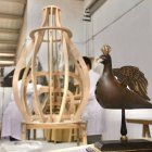 Treballs al taller Santuari per construir l'estructura de la nova Àguila de Valls, amb la maqueta en primer terme.