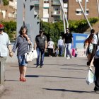 Diverses persones amb gorres i barrets caminen sota la intensa calor.